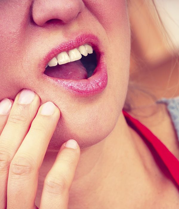 Woman clutching jaw in pain